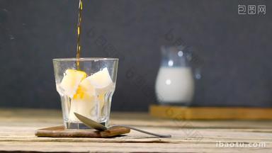 Pouring hot coffee in glass with milk ice cubes